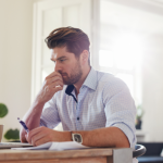 Professional man concentrating on financial paperwork and a computer