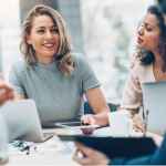 A diverse group of four professionals in a meeting discussing business in a modern office.