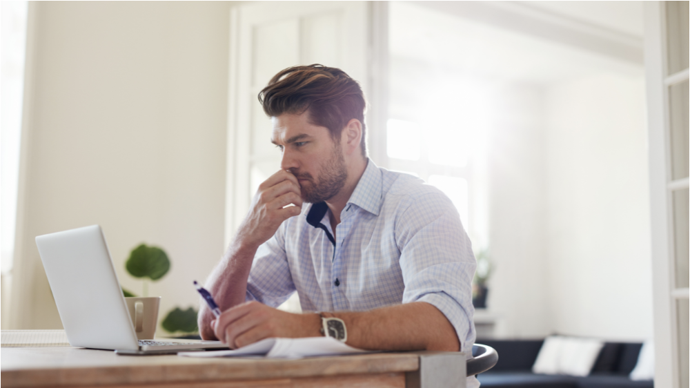 Professional man concentrating on financial paperwork and a computer