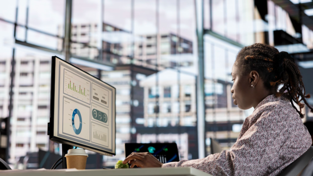 Business owner reviewing a financial dashboard on a desktop screen in a modern office
