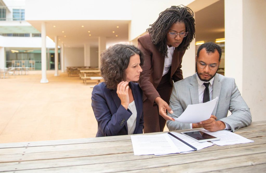 Business team reviewing financial documents and unpaid invoices while assessing cash flow warning signs before business rescue
